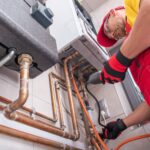 Technician inspecting pipework with fixed gas detector to identify any potential leaks.