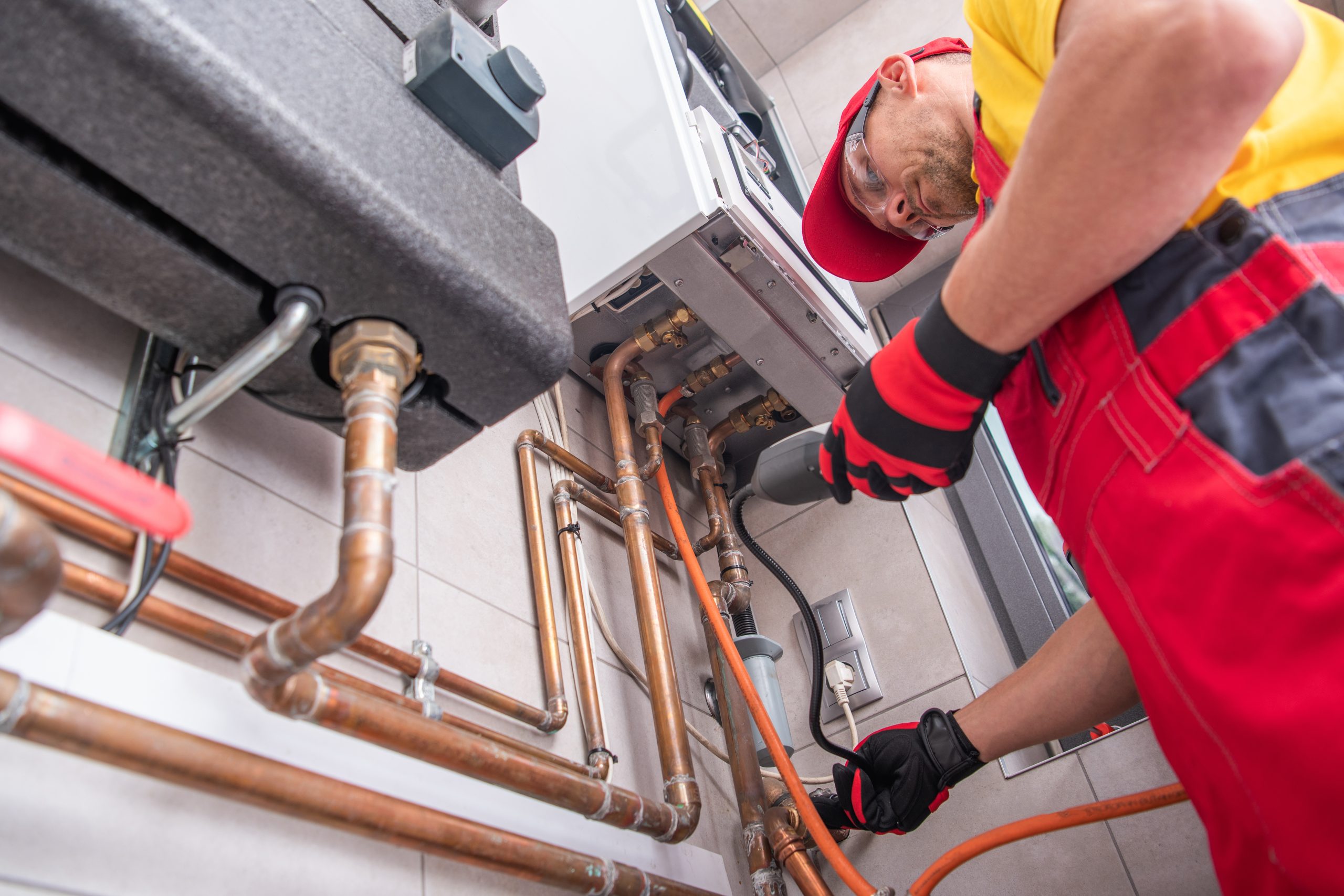 Technician inspecting pipework with fixed gas detector to identify any potential leaks.
