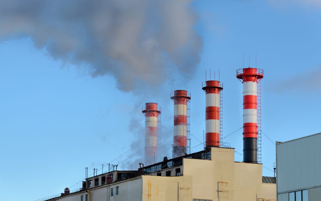 Industrial facility with smokestacks emitting gases, illustrating what are fugitive emissions and their environmental impact
