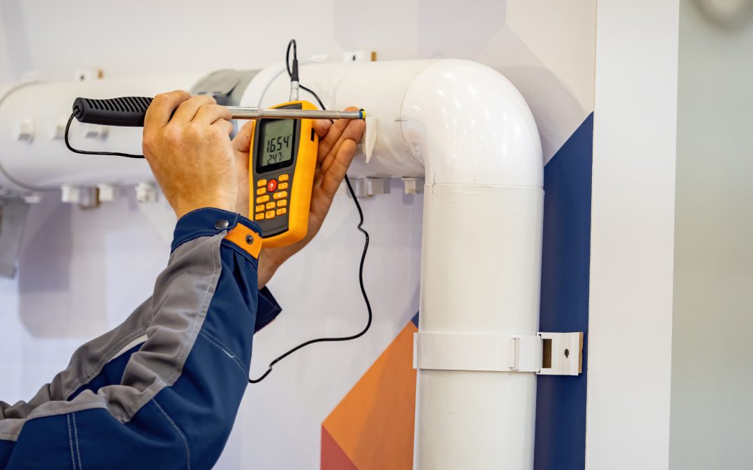 Technician using a handheld device for gas monitoring, ensuring safety and compliance in an industrial setting.
