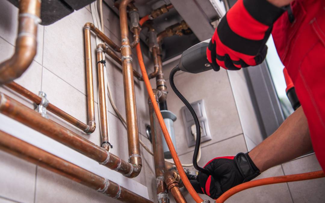 A technician uses a gas leak detector to inspect copper pipes for leaks, ensuring safe and reliable gas storage solutions.
