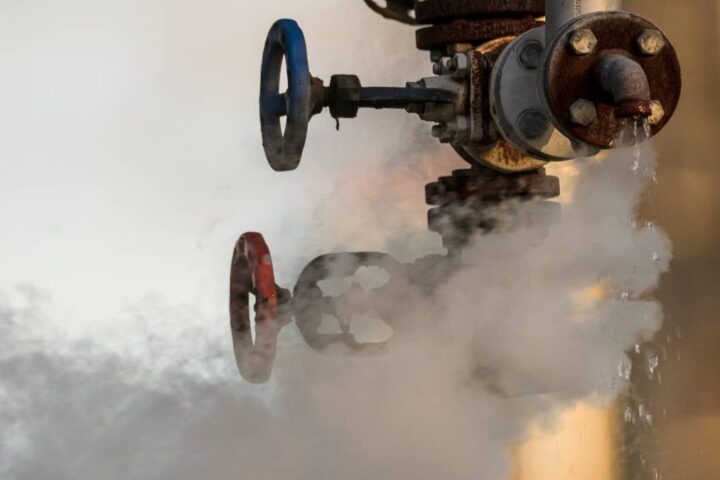 Close-up of a leaking gas valve emitting steam, illustrating the urgency of knowing who to call for gas leak situations.