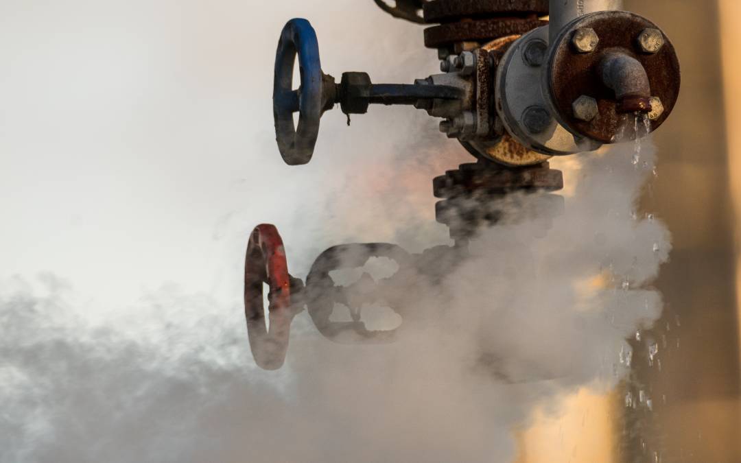 Close-up of a leaking gas valve emitting steam, illustrating the urgency of knowing who to call for gas leak situations.