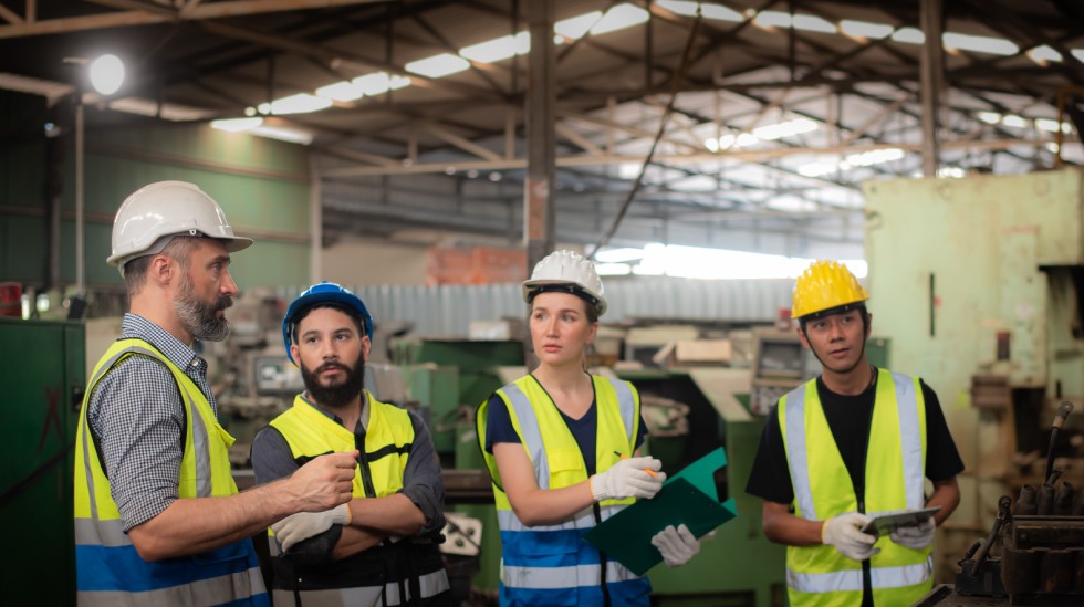 Workers discussing safety protocols during LDAR training in a gas facility, focusing on leak detection and repair procedures.