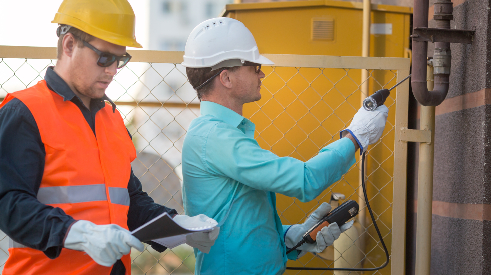 Engineers inspecting pipelines and recording data with tools to ensure compliance with EPA LDAR regulations standards